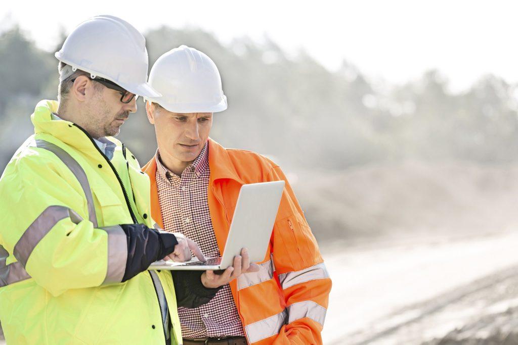 2 hommes sur un chantier en train d'utiliser un logiciel de gestion de chantier