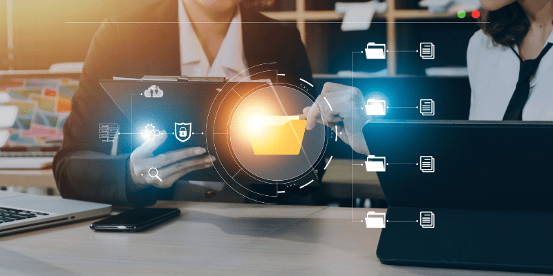 Deux professionnels du BTP collaborent avec des outils numériques autour d’un système de gestion électronique des documents (GED)