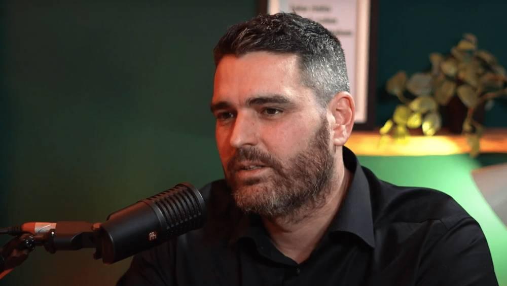 Portrait de Cyril Perrin, Directeur général exécutif d'Orisha Construction, s'exprimant devant un micro de studio.