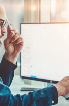 Homme devant logiciel pour calcule du déboursé sec BTP