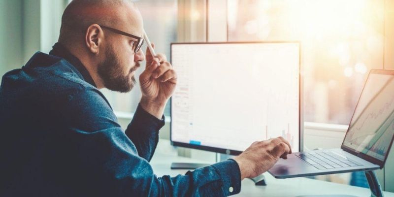 Homme devant logiciel pour calcule du déboursé sec BTP